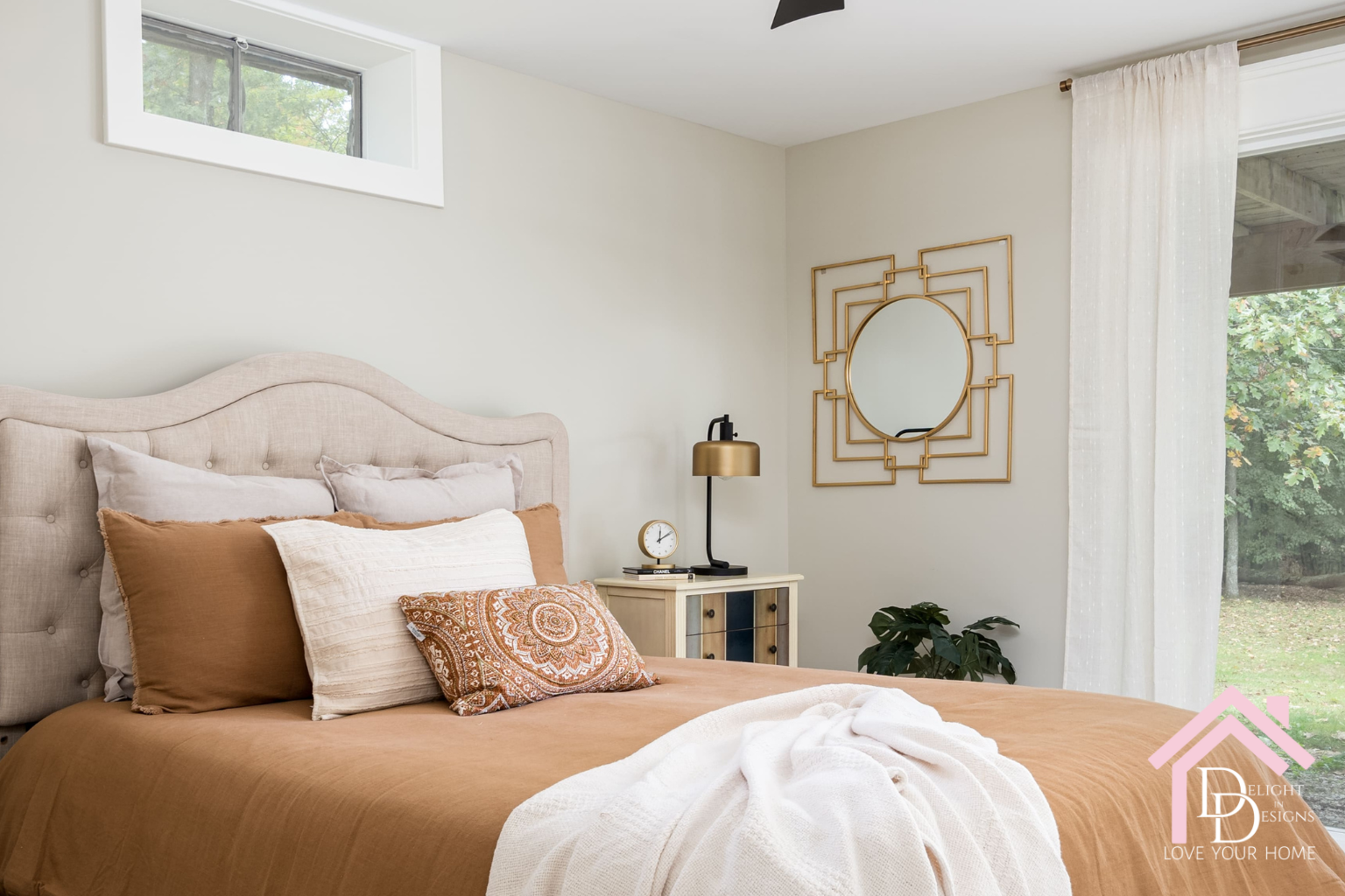 pretty bedroom with gold mirror on wall
