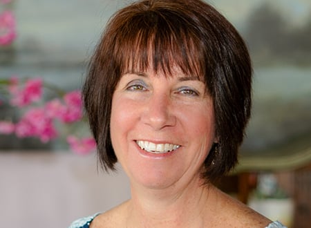 a woman with short brown hair smiling at the camera.