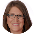 a woman with glasses is smiling for a picture.