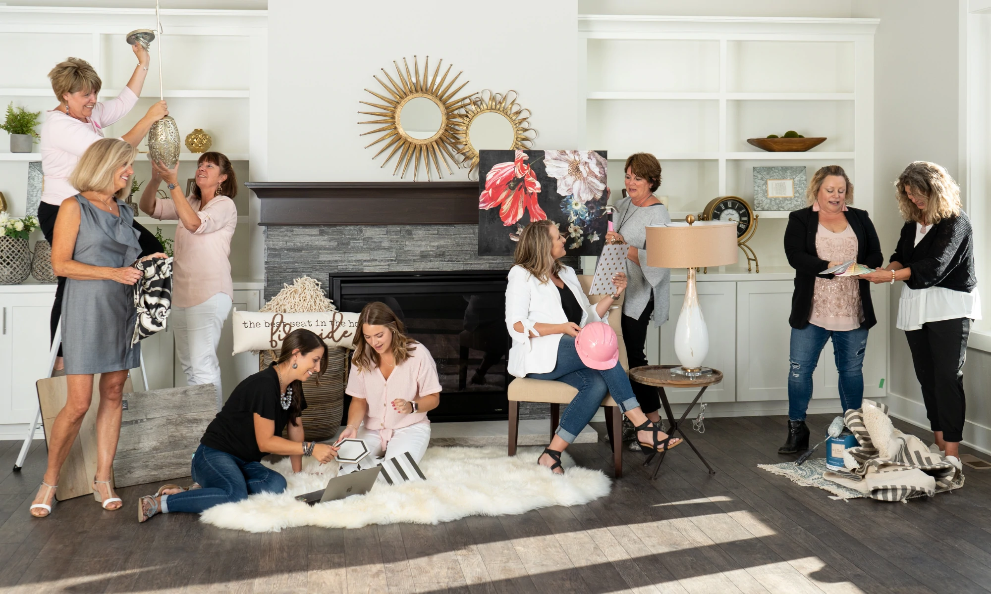 a group of women standing and sitting around a living room.