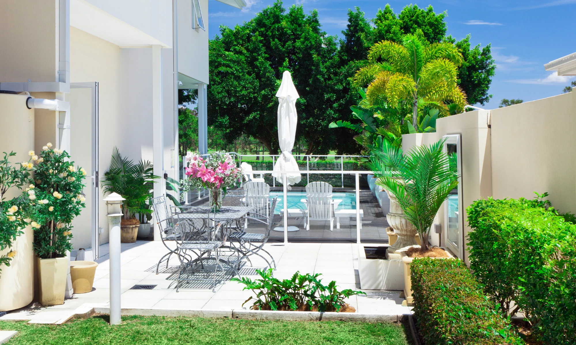a patio with a table, chairs and umbrella.