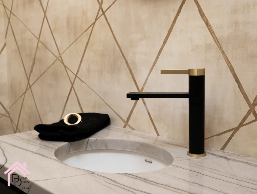 a bathroom sink with a black towel and a gold faucet.
