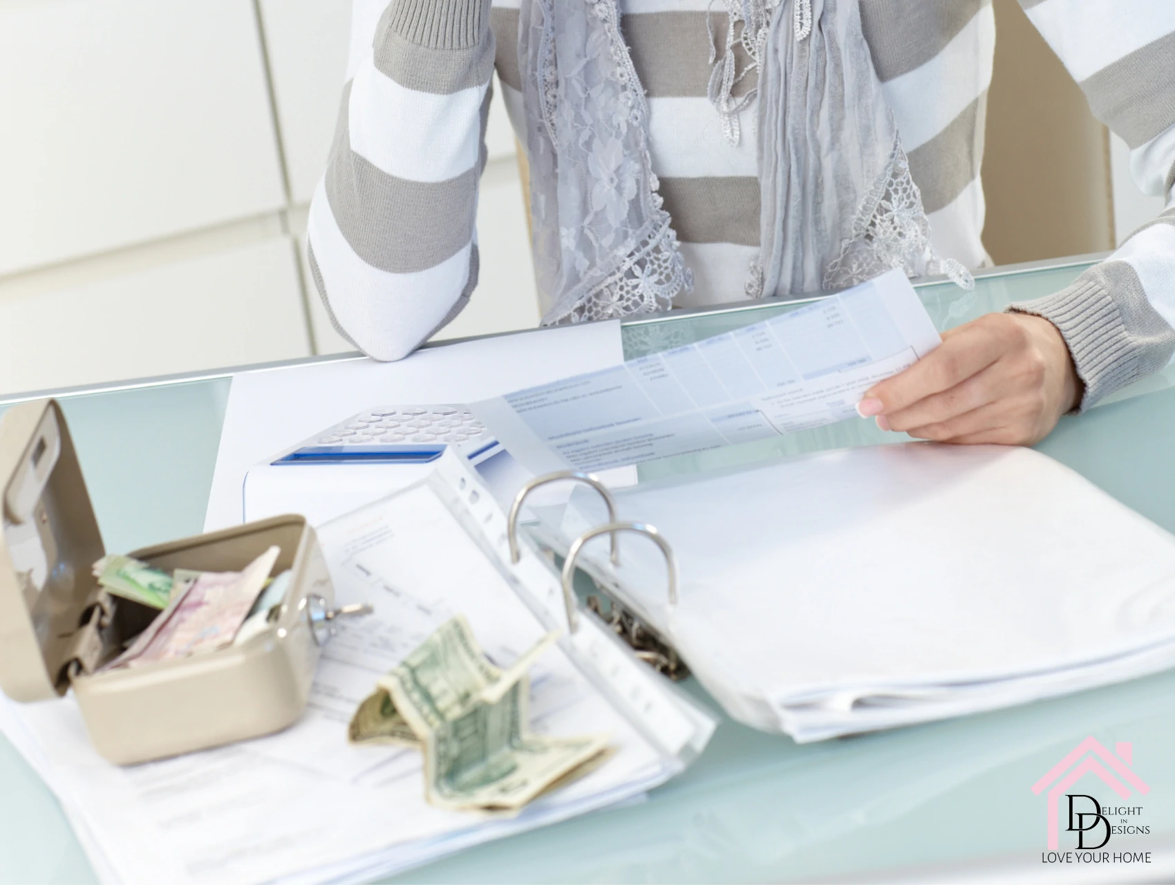 a woman sitting at a table with a binder and money.