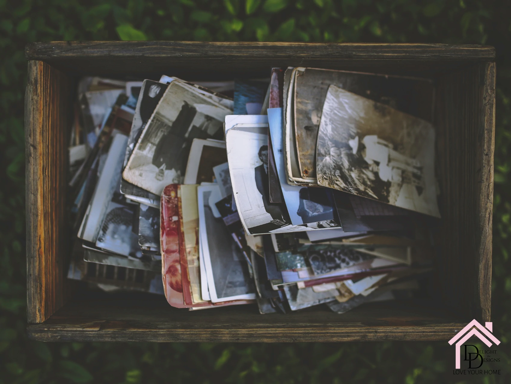 a wooden box filled with magazines on top of a grass covered field.