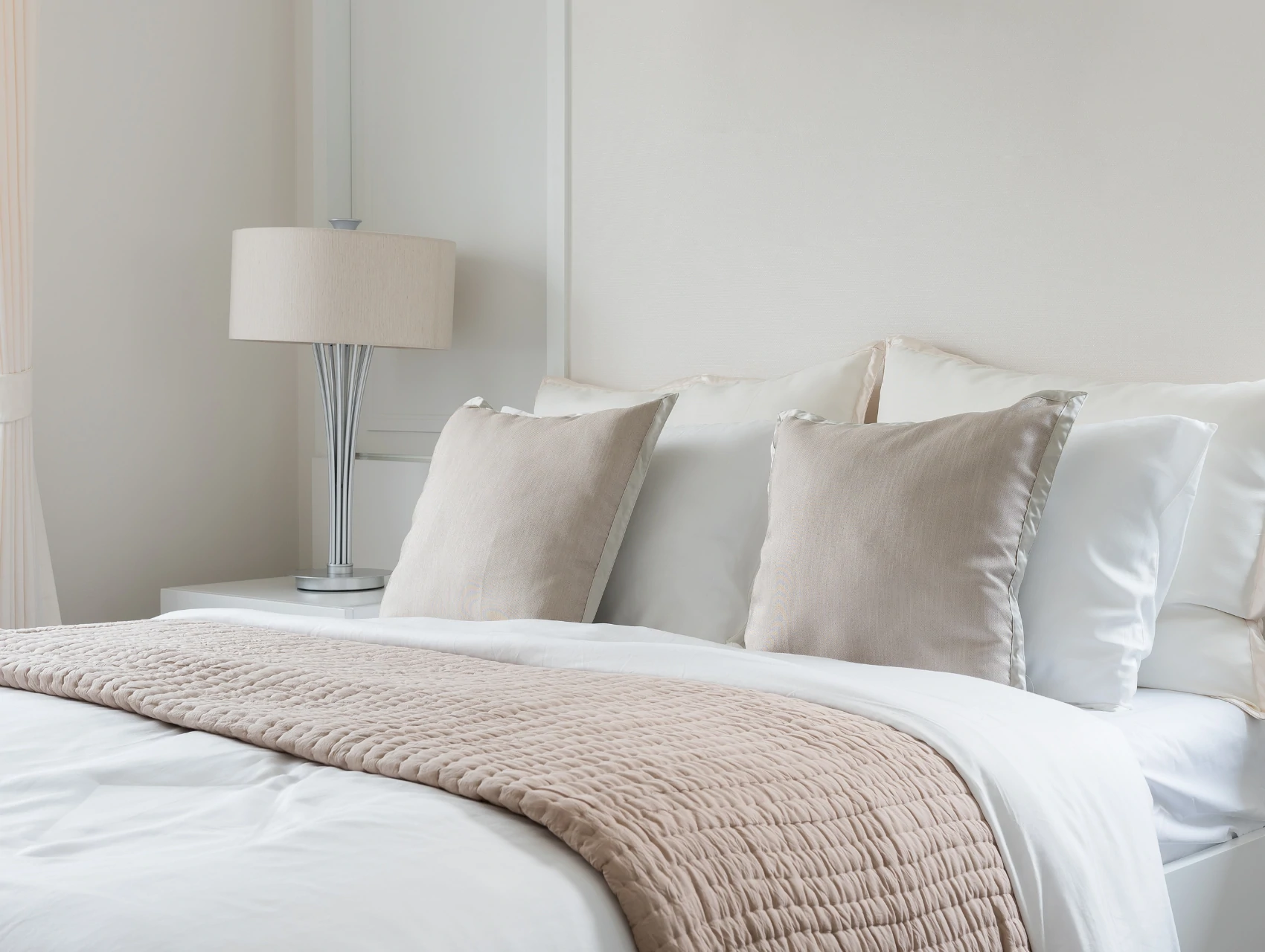 a bed with a white comforter and pillows.