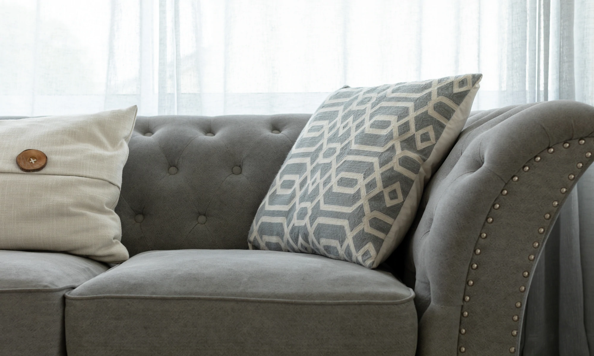 a gray couch with two pillows on top of it.