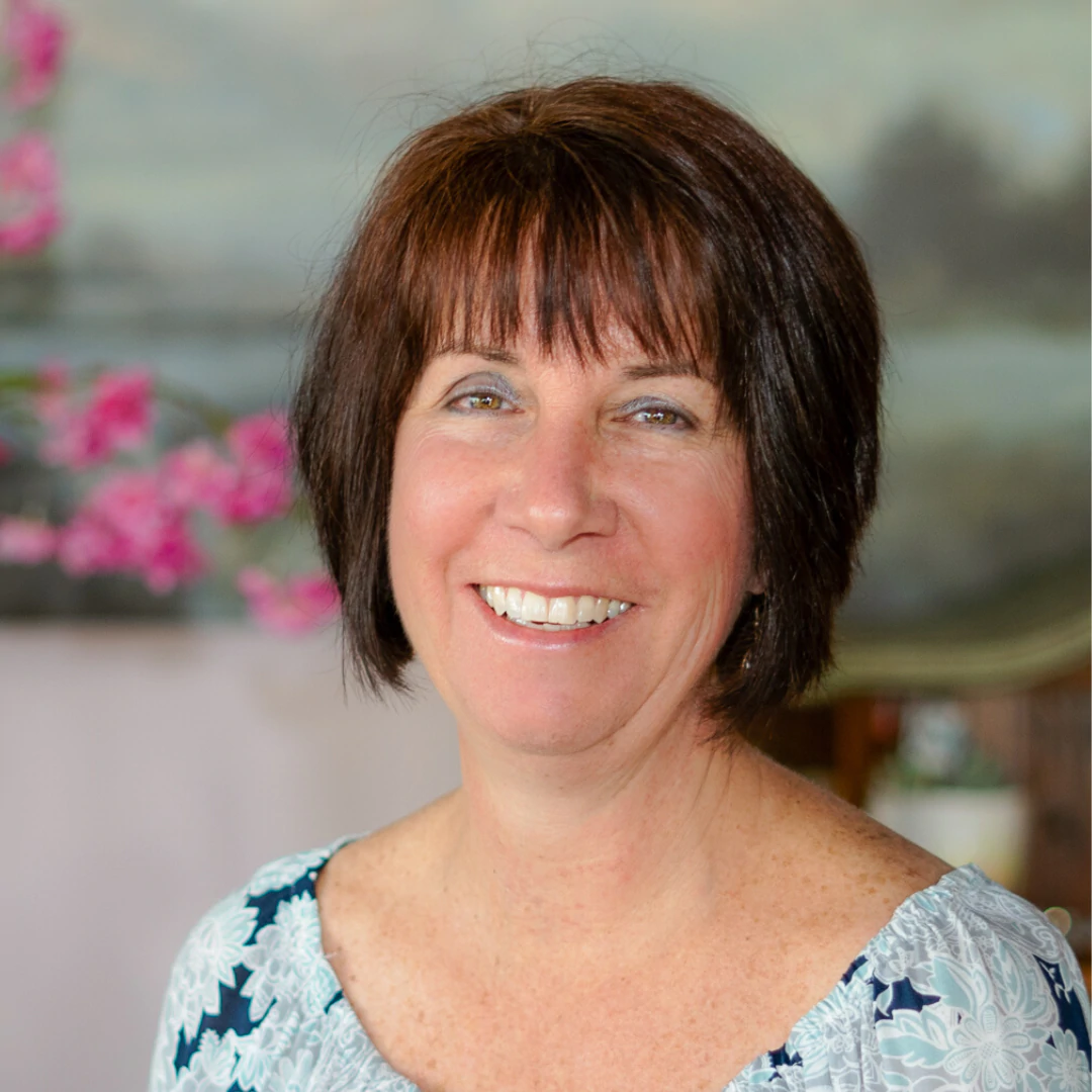 a woman with short brown hair smiling at the camera.