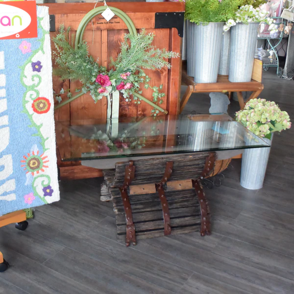 a glass table with a bunch of flowers on it.