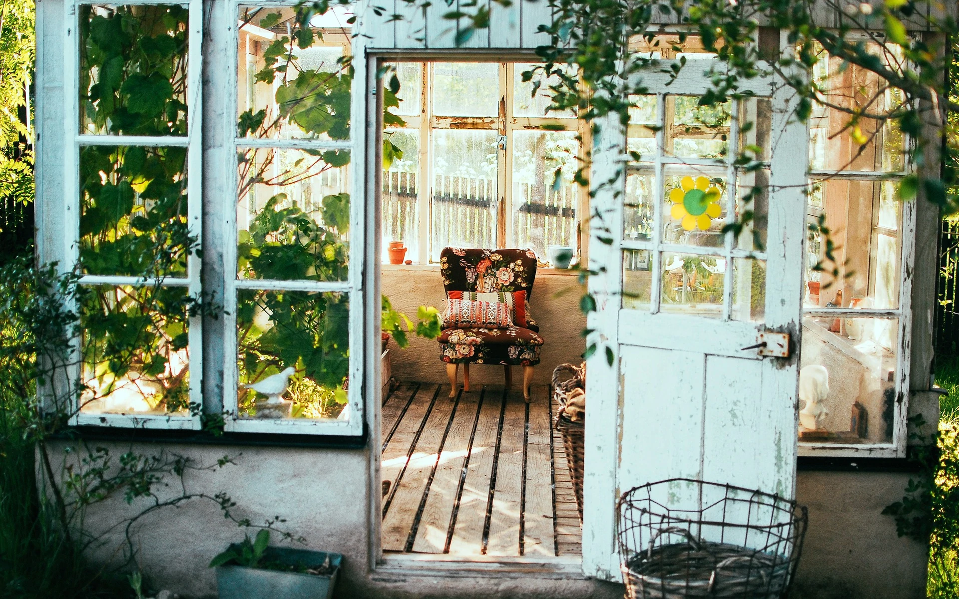 an open door leading into a room with a chair and potted plant.