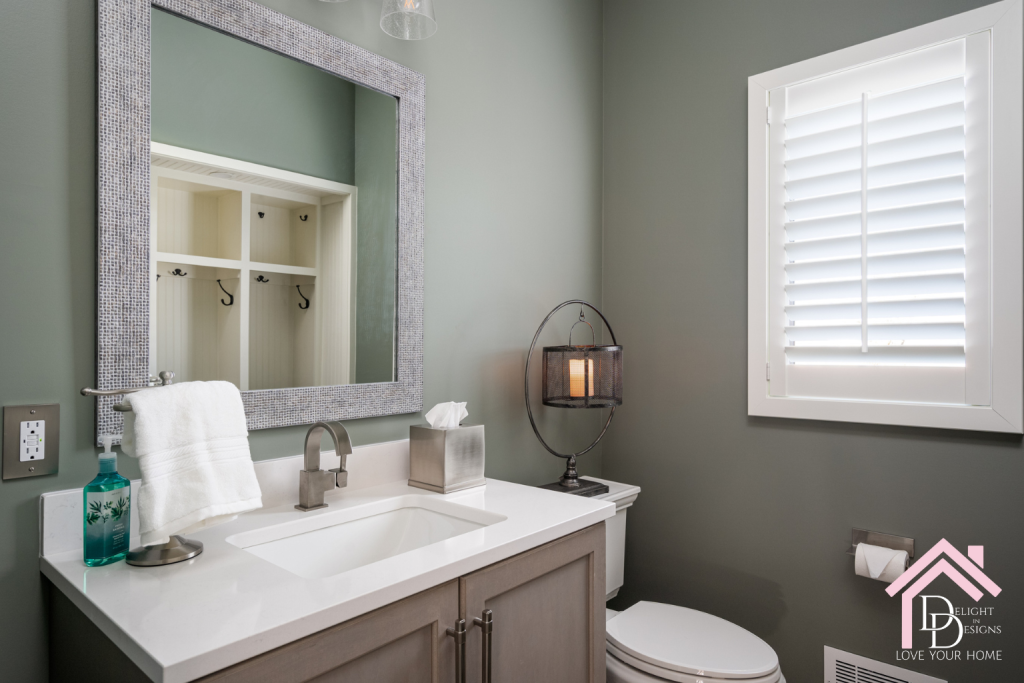 Guest bathroom with green gray walls. Square textured vanity with a natural wood vanity with white countertops. New Year Resolutions